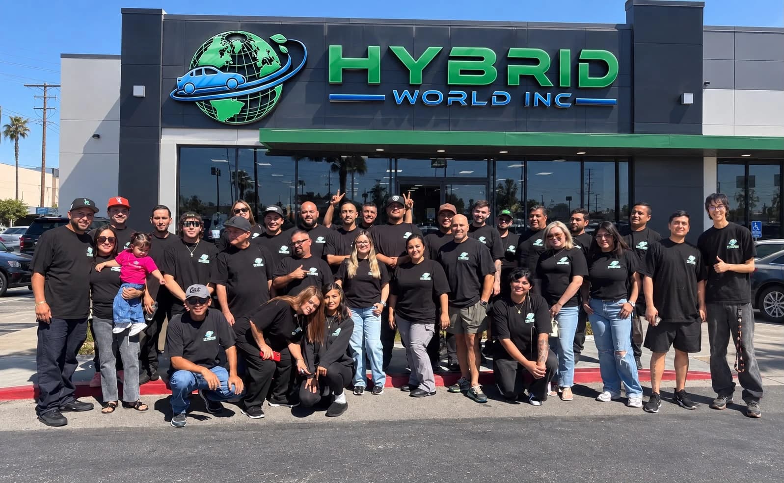 El equipo de Hybrid World, con las camisetas de la empresa, frente a la fachada de Hybrid World Inc